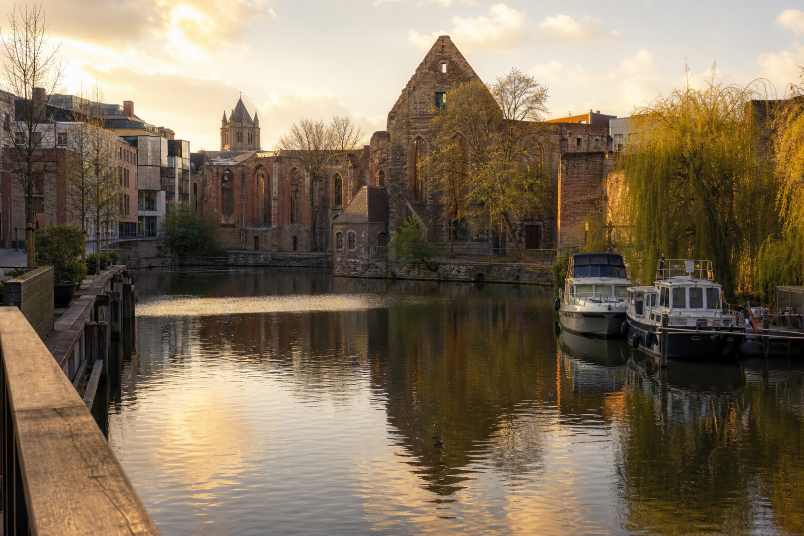 Artistic image of the confluence of two rivers in Ghent: abbey ruins on one bank, a modern marina on the other, in the light of the setting sun.