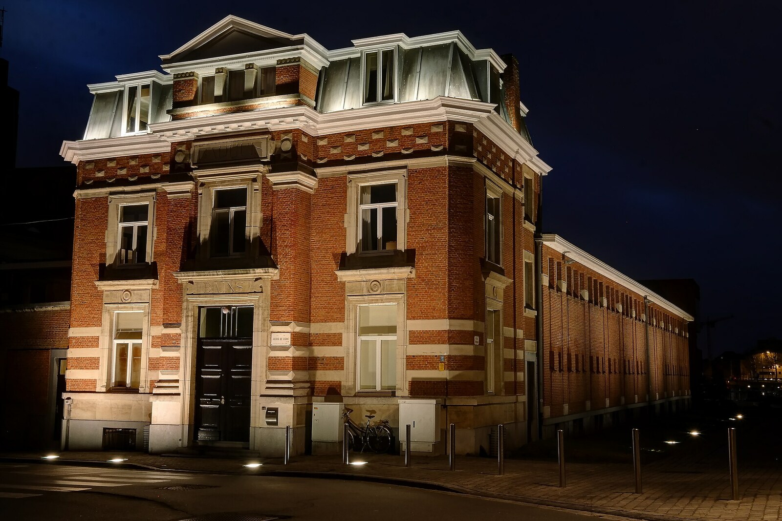 Facade of the Van Eyck Swimming Pool with decorative columns and a large glass wall.