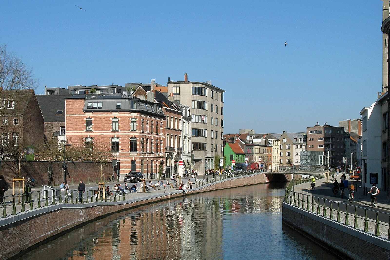 The new stretch of the De Reep river, with renewed embankments, greenery, and a bridge in the background.