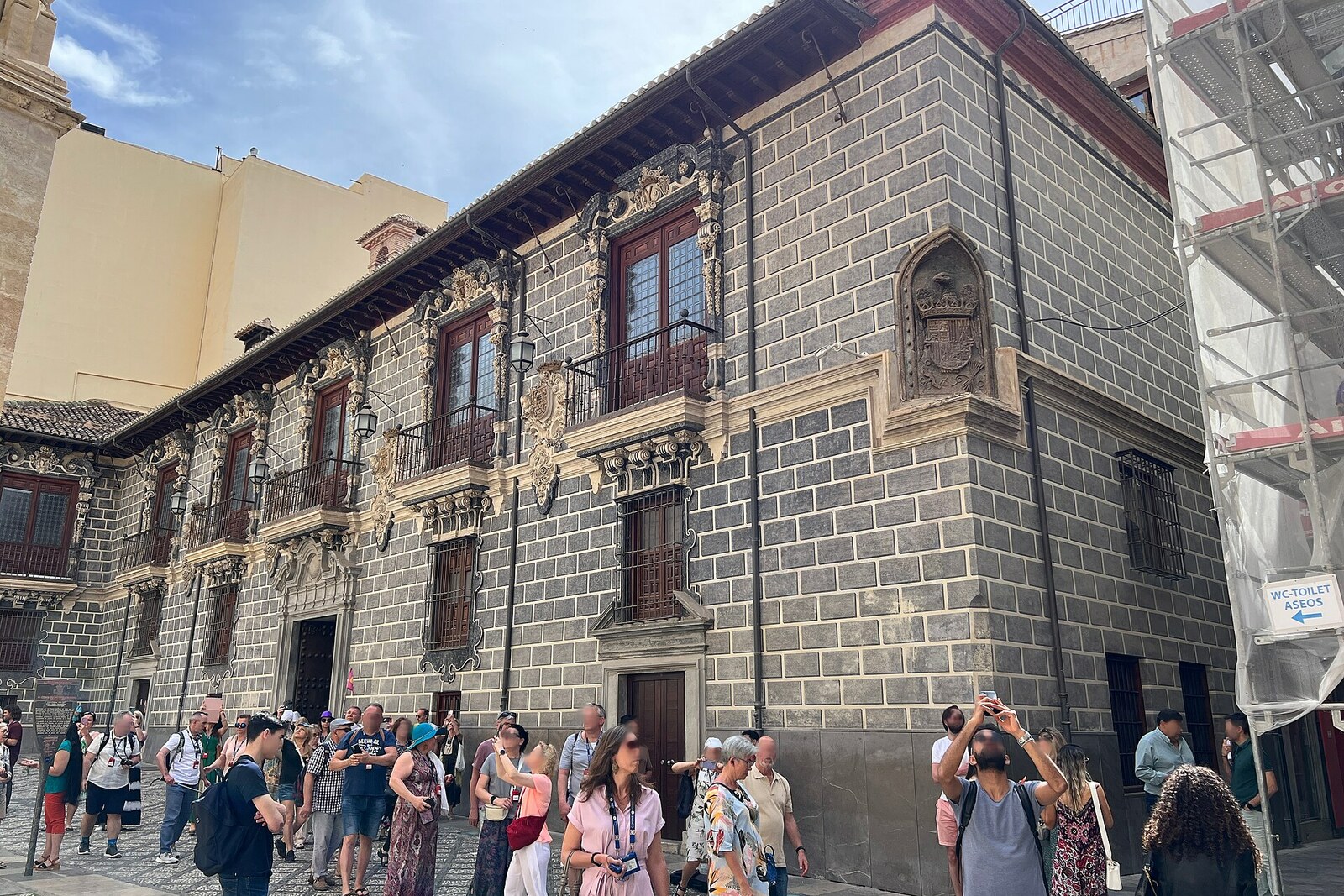 Baroque façade of the palace of the Madrasa of Granada, with columns and a coat of arms