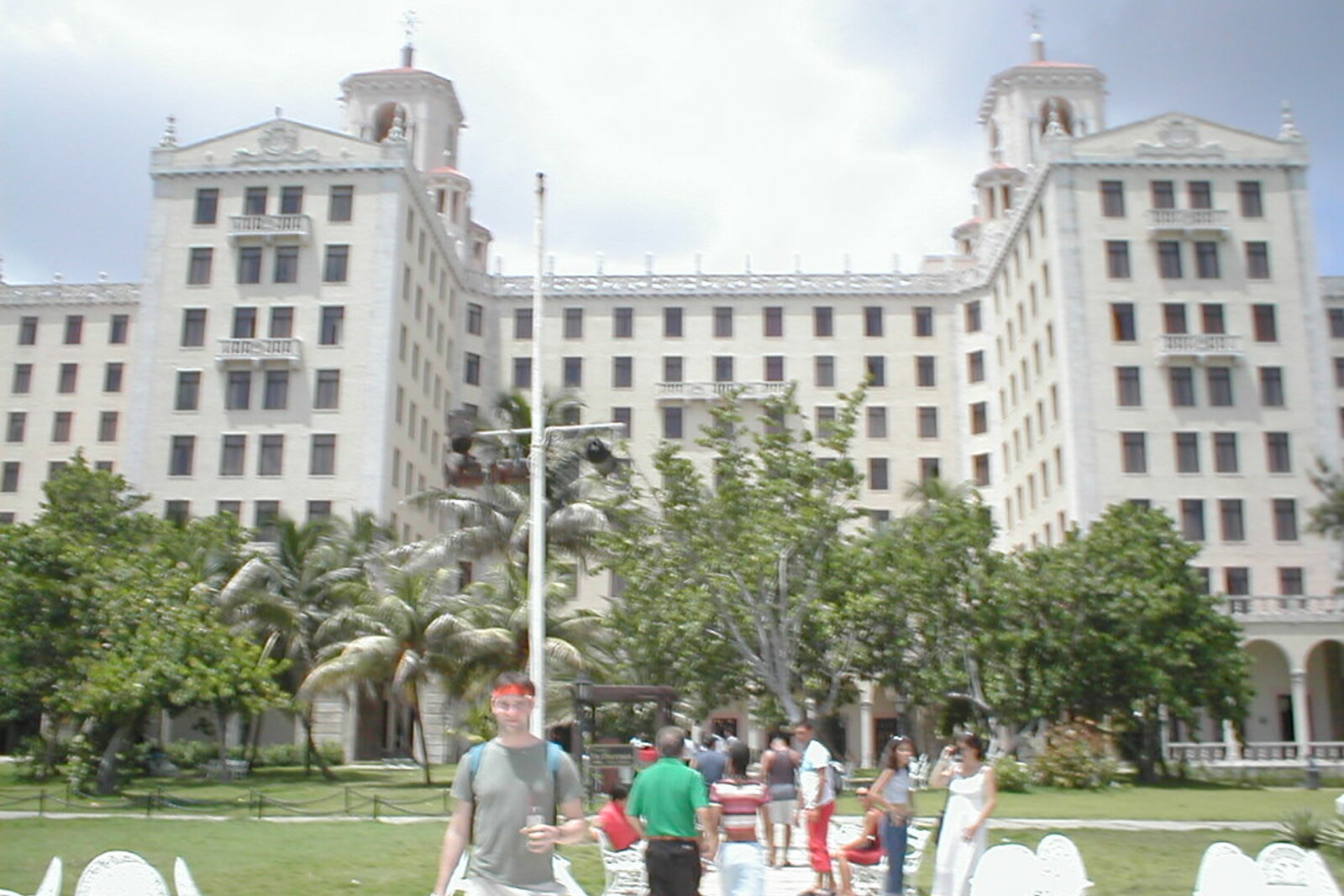 The facade of Hotel Nacional de Cuba with columns and turrets; a well-kept garden stretches out before the building.