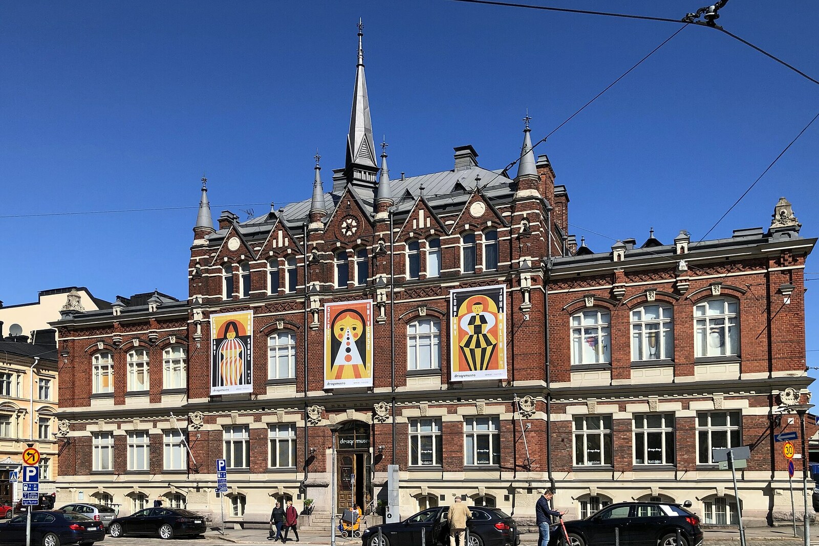 The façade of the design museum, with brick walls and tall Gothic-style windows