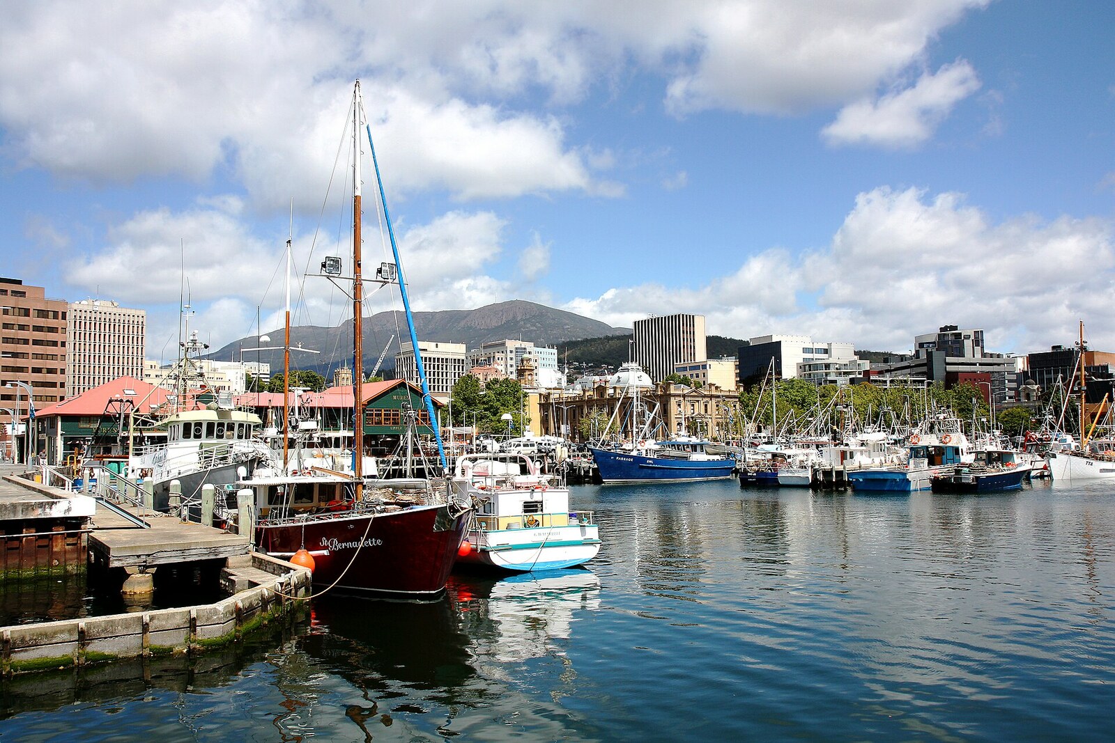 Boats at the Hobart waterfront, with the city and a mountain in the distance.