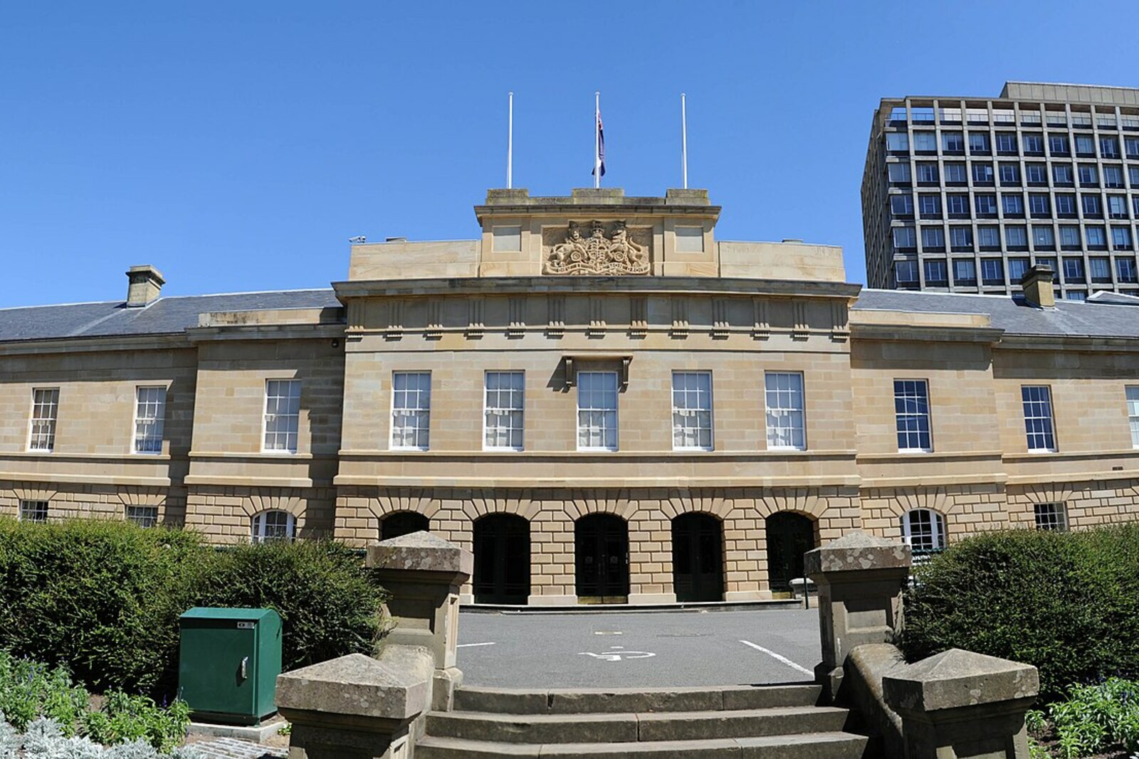 The long sandstone facade of Hobart Parliament House with five central arches.