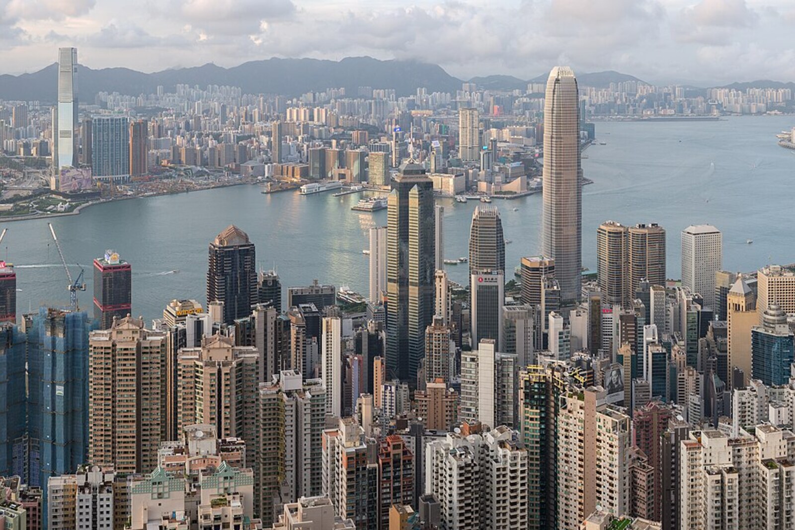A panorama of Hong Kong from above: the harbour, skyscrapers, and mountains visible from the trail.