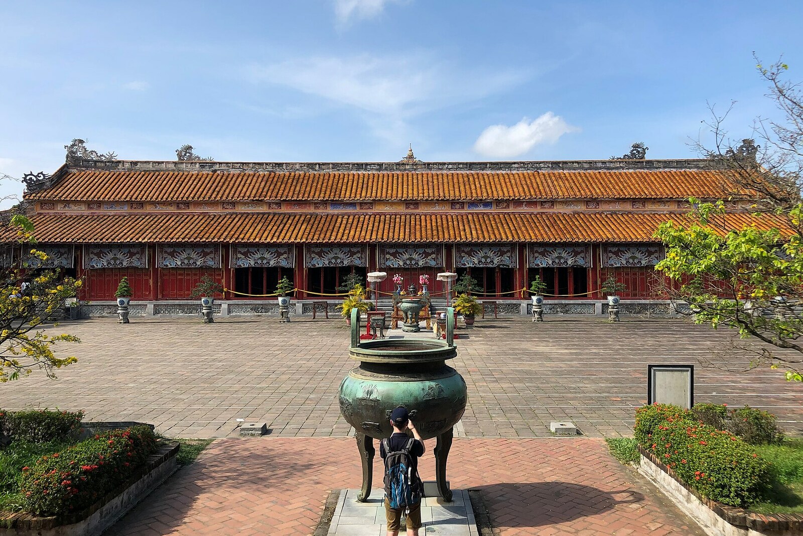 The red facade of The Mieu Temple and a bronze urn in the courtyard