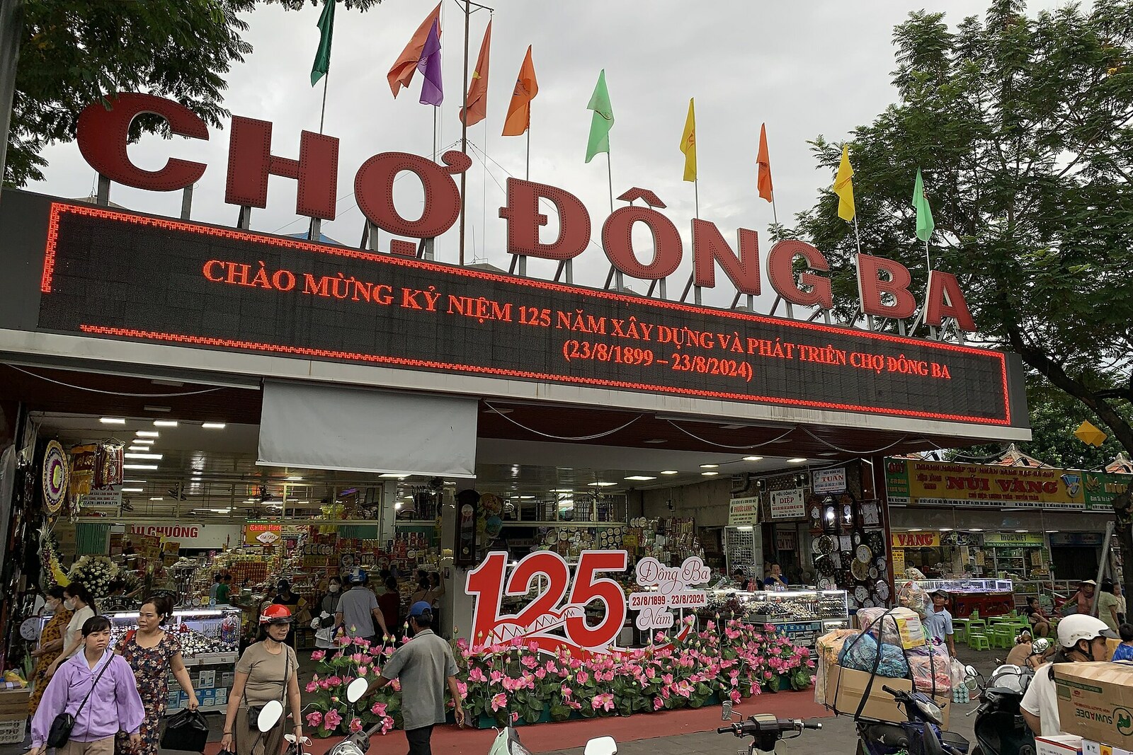Sign and main entrance of Dong Ba Market with July 2024 anniversary decorations