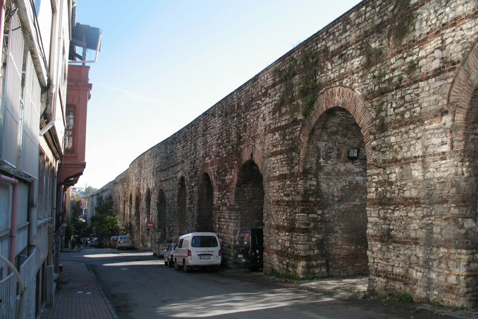 The stone arches of the Aqueduct of Valens above a busy avenue