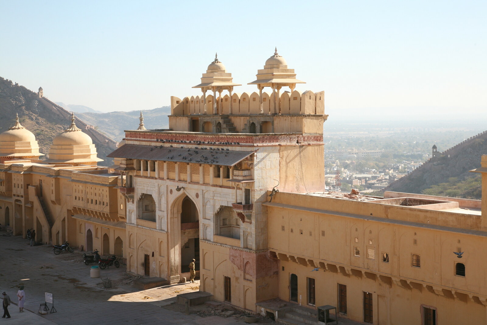 Suraj Pol gate with towers and an arch against the backdrop of a hill.