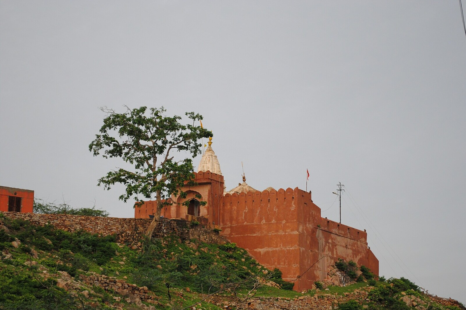 A stone sun temple on a hilltop with carved walls