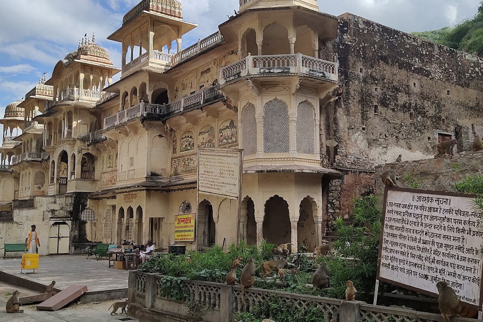 The pink Galtaji temple with galleries and a cliff behind it