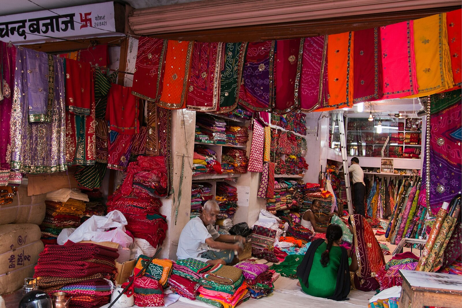 A shop on Tripolia Bazaar filled with quilted bedspreads, blankets, and colorful textiles.