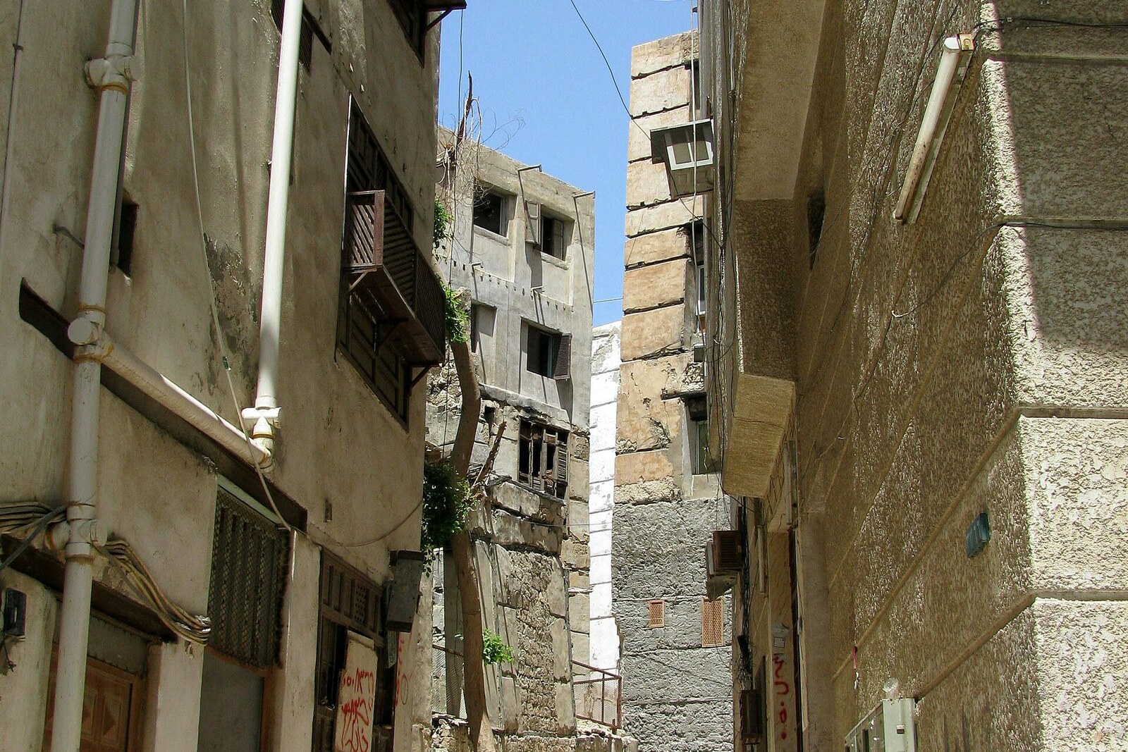 A narrow alley in Al-Alawi Market between coral houses