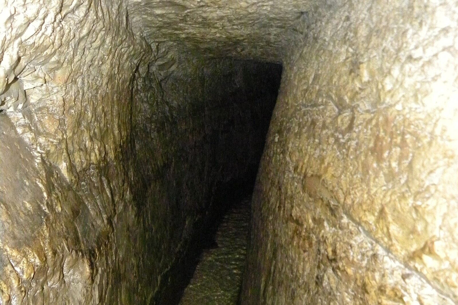 interior view of Hezekiah's Tunnel with running water and flashlight beams