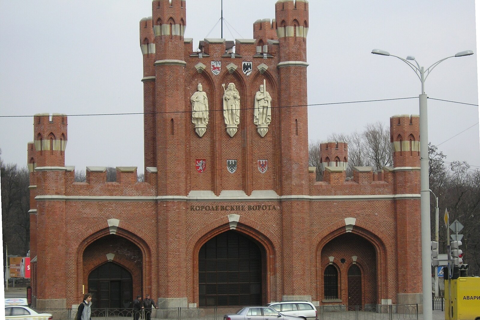 The brick facade of King's Gate, with three figures above the central arch.