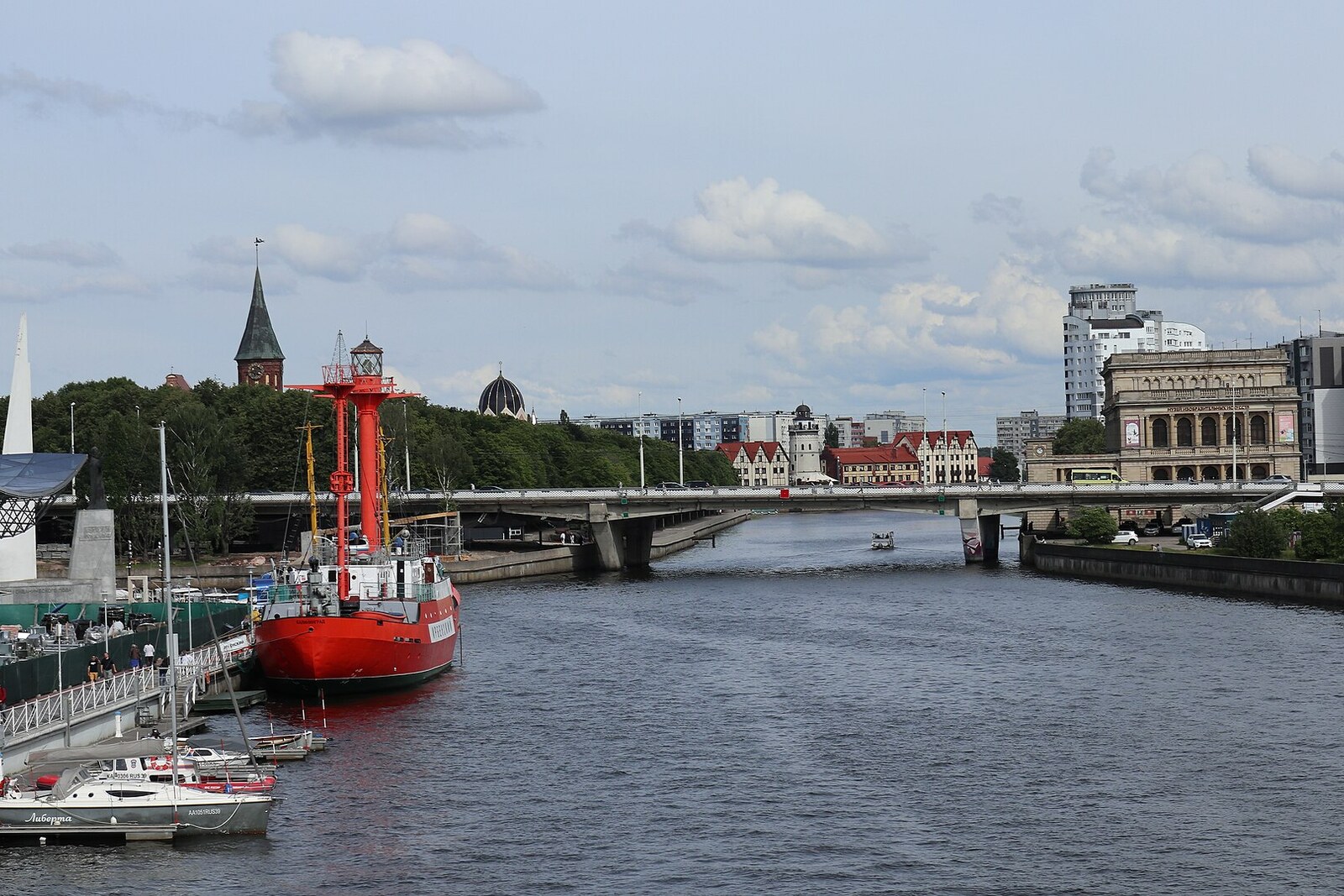 The concrete Estacade Bridge across the Pregolya, with a museum ship by the embankment.