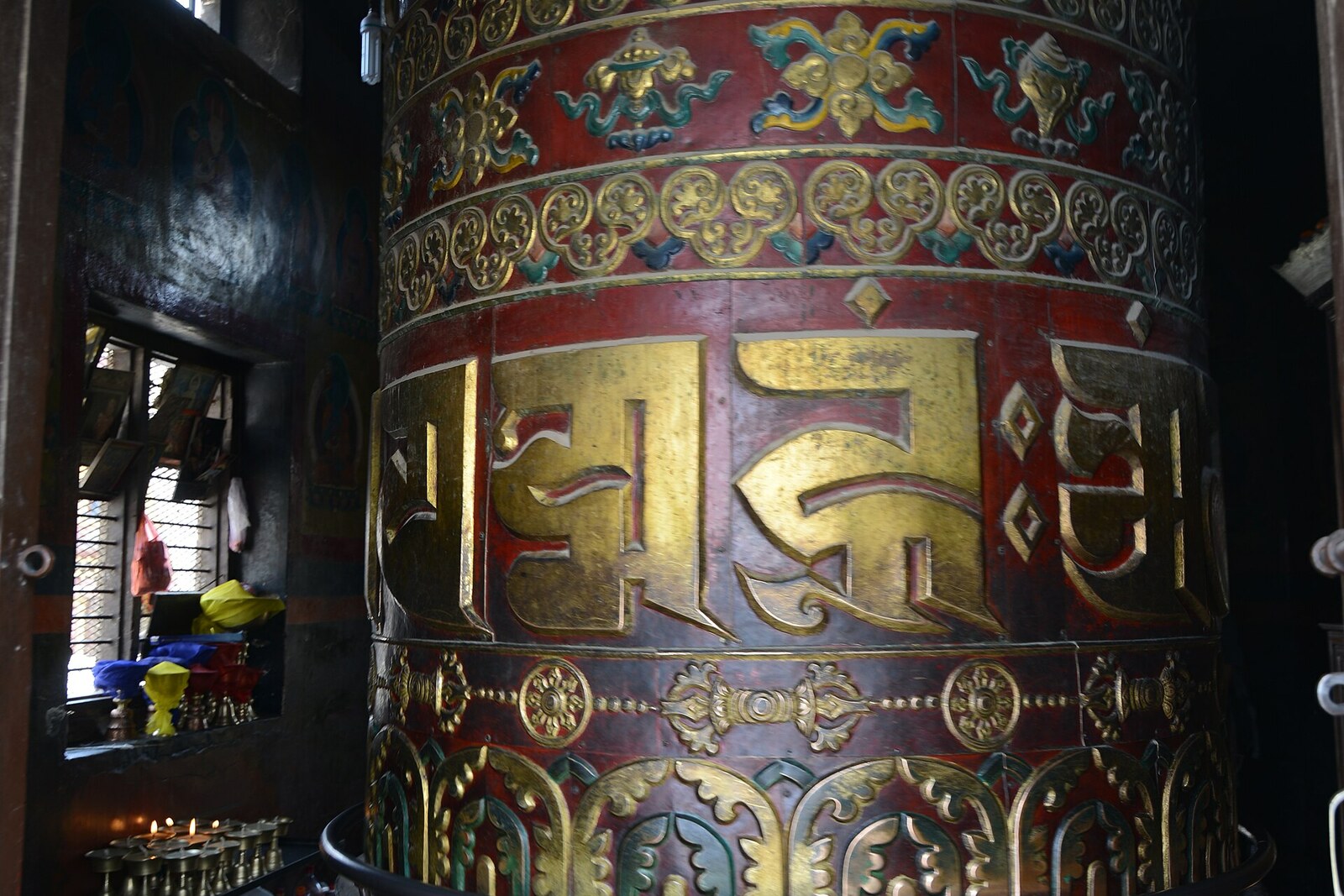 A large golden prayer wheel in a red frame