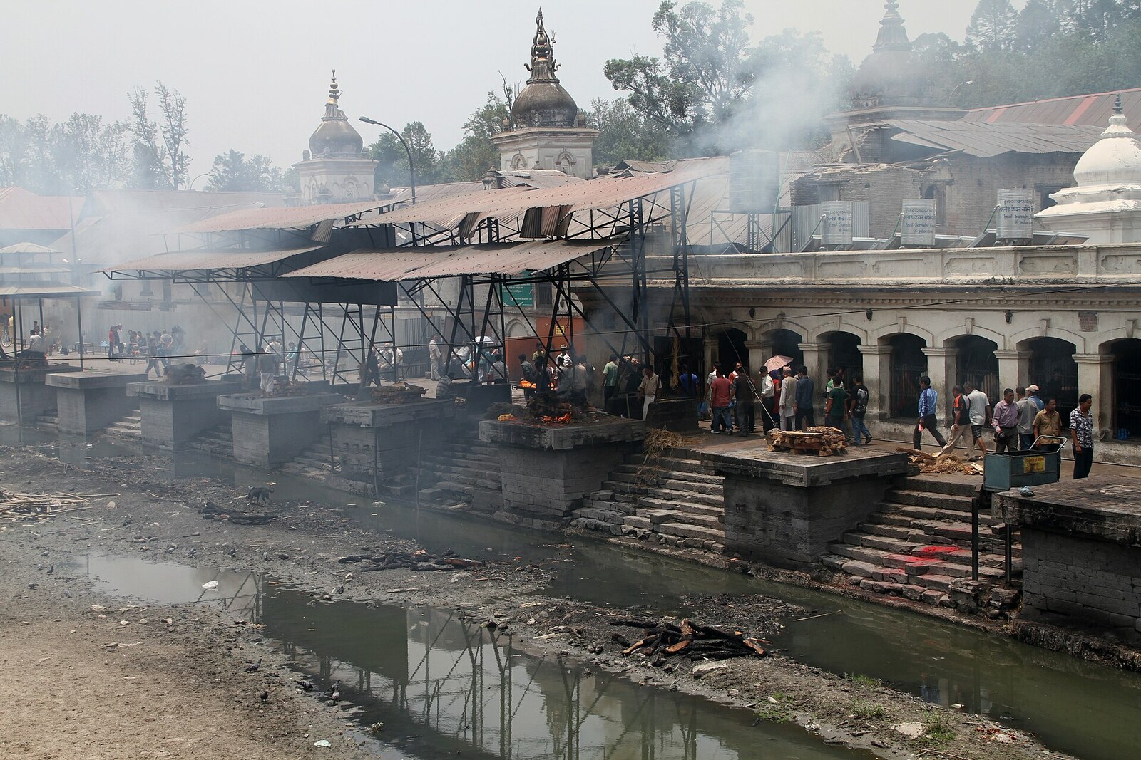 Stone platforms and smoking pyres on the bank of the Bagmati at Pashupatinath Temple