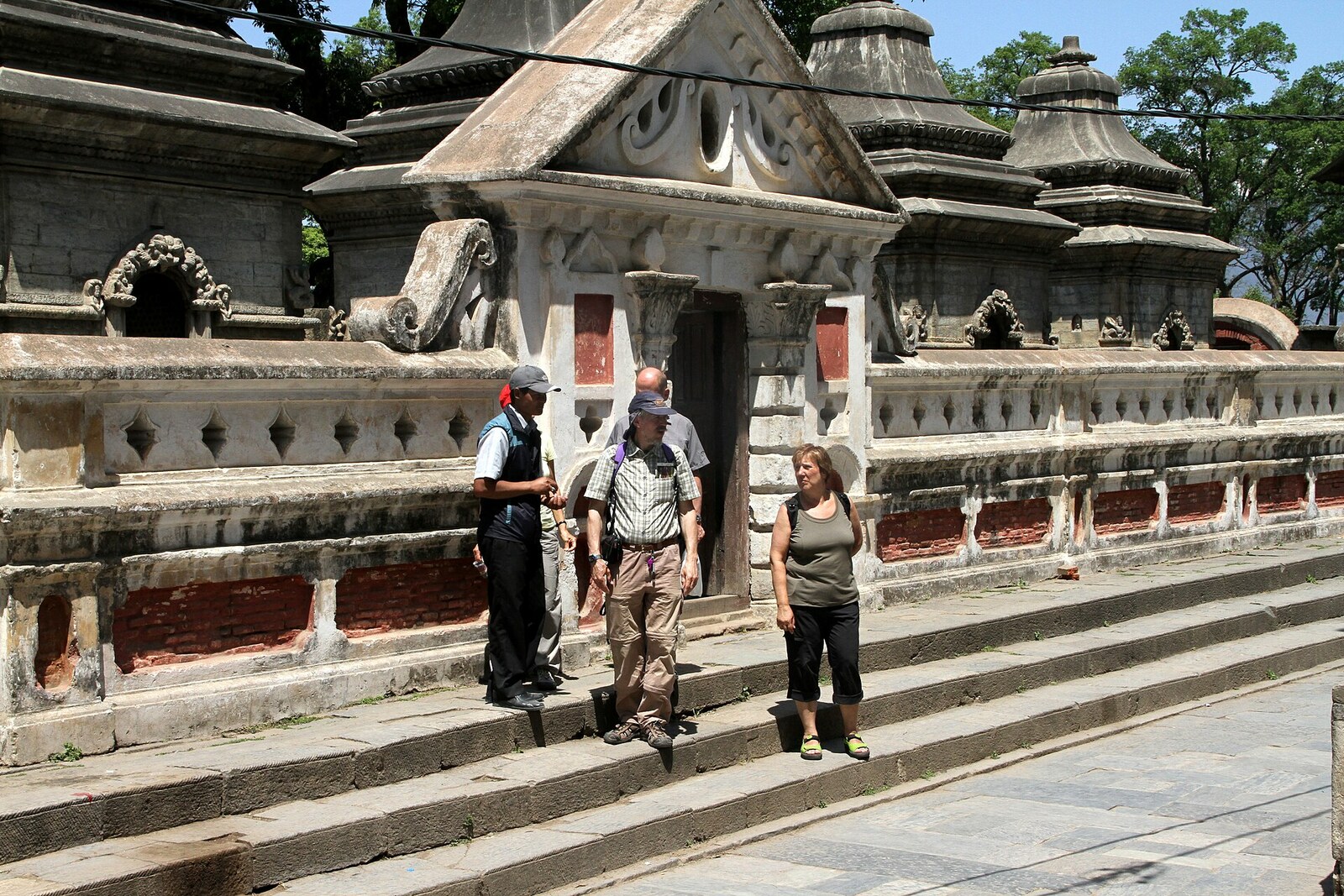 The green hill of Mrigasthali with a stone building and people resting