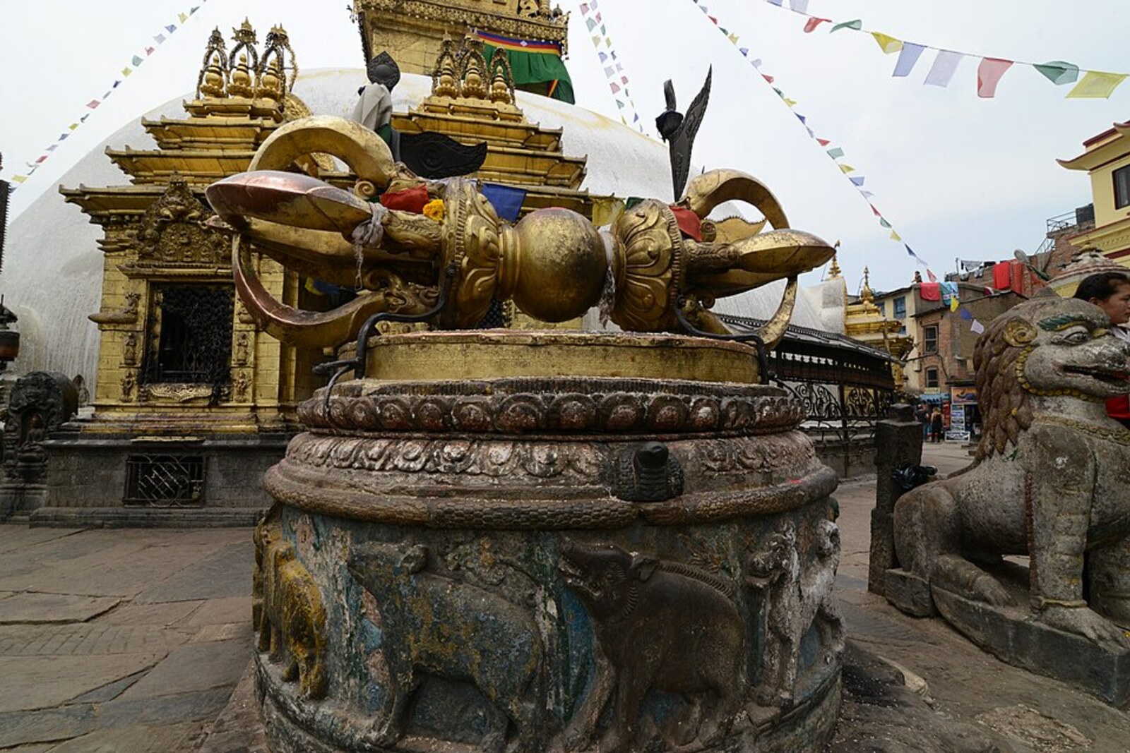 A large bronze Vajra with golden ornamentation and lions on either side.