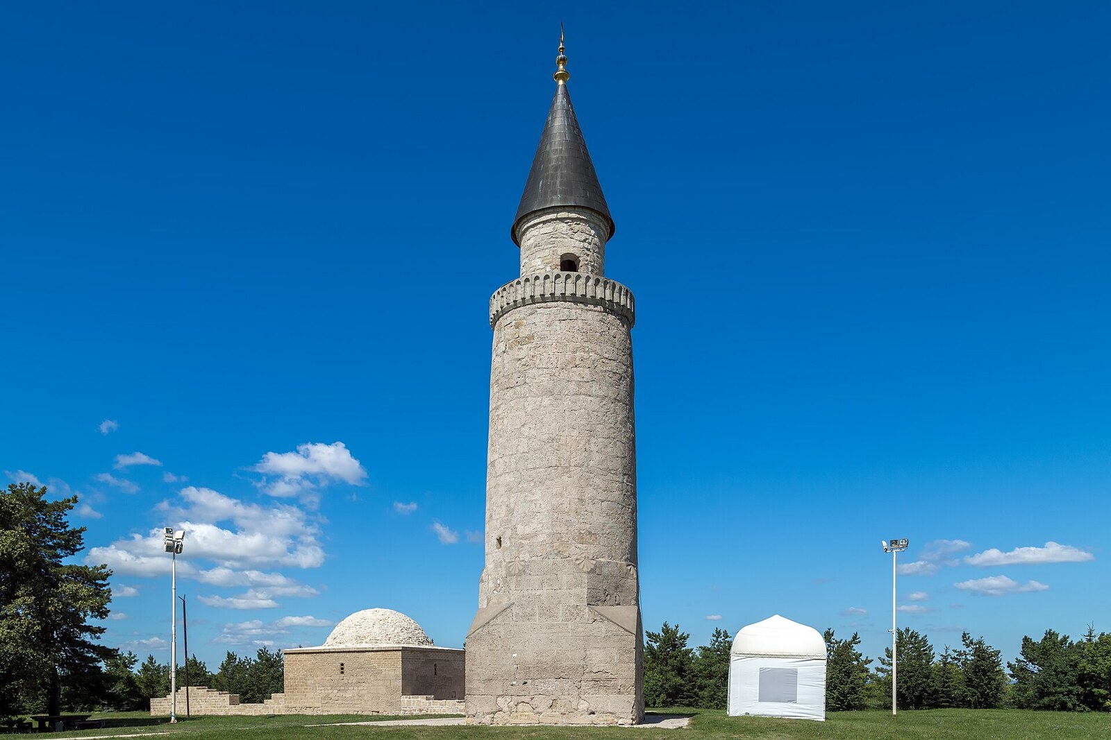 The Small Minaret and Khan's Tomb amid grass in Bolgar.