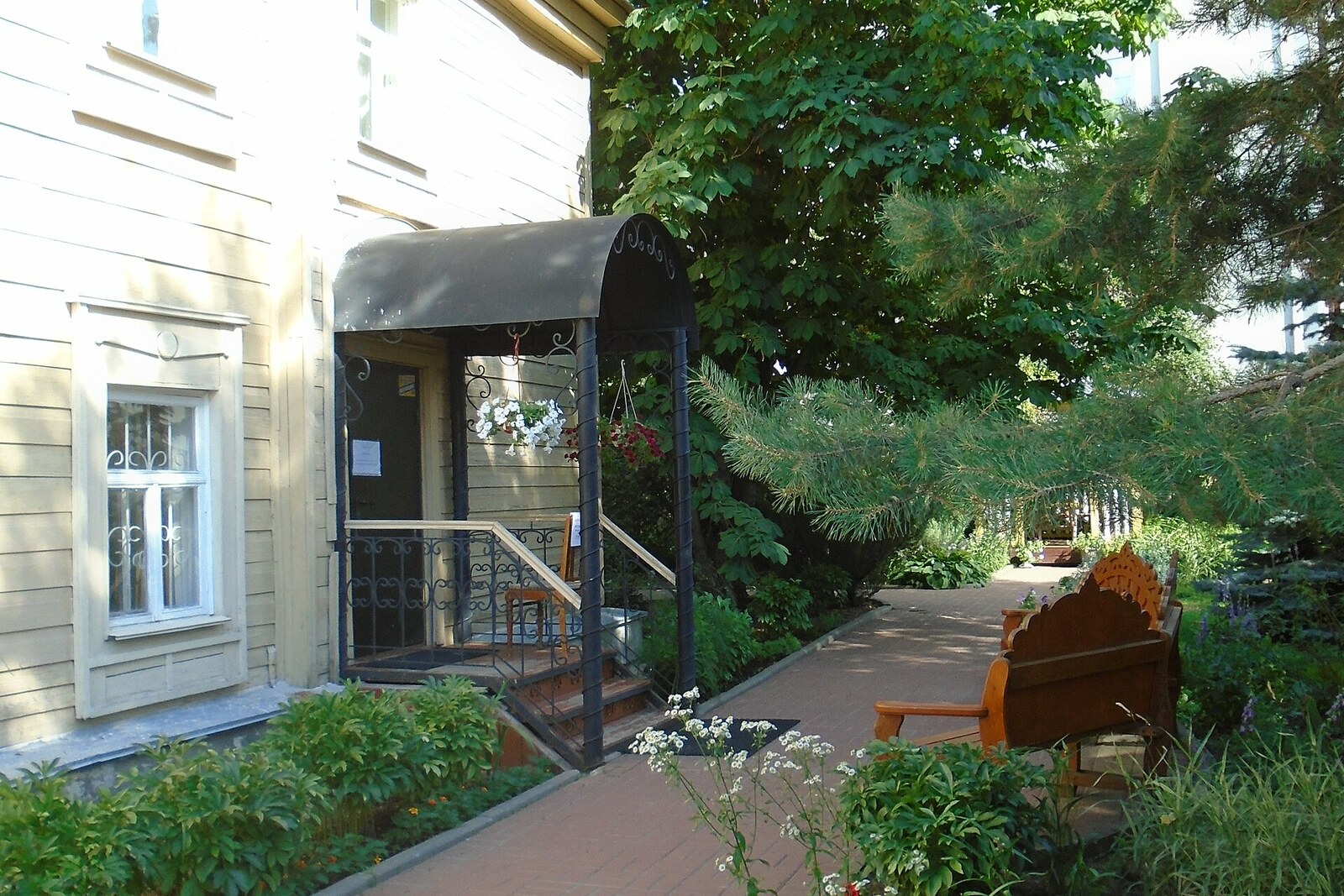 A wooden house and the entrance to the courtyard of the Qayum Nasiri Museum.