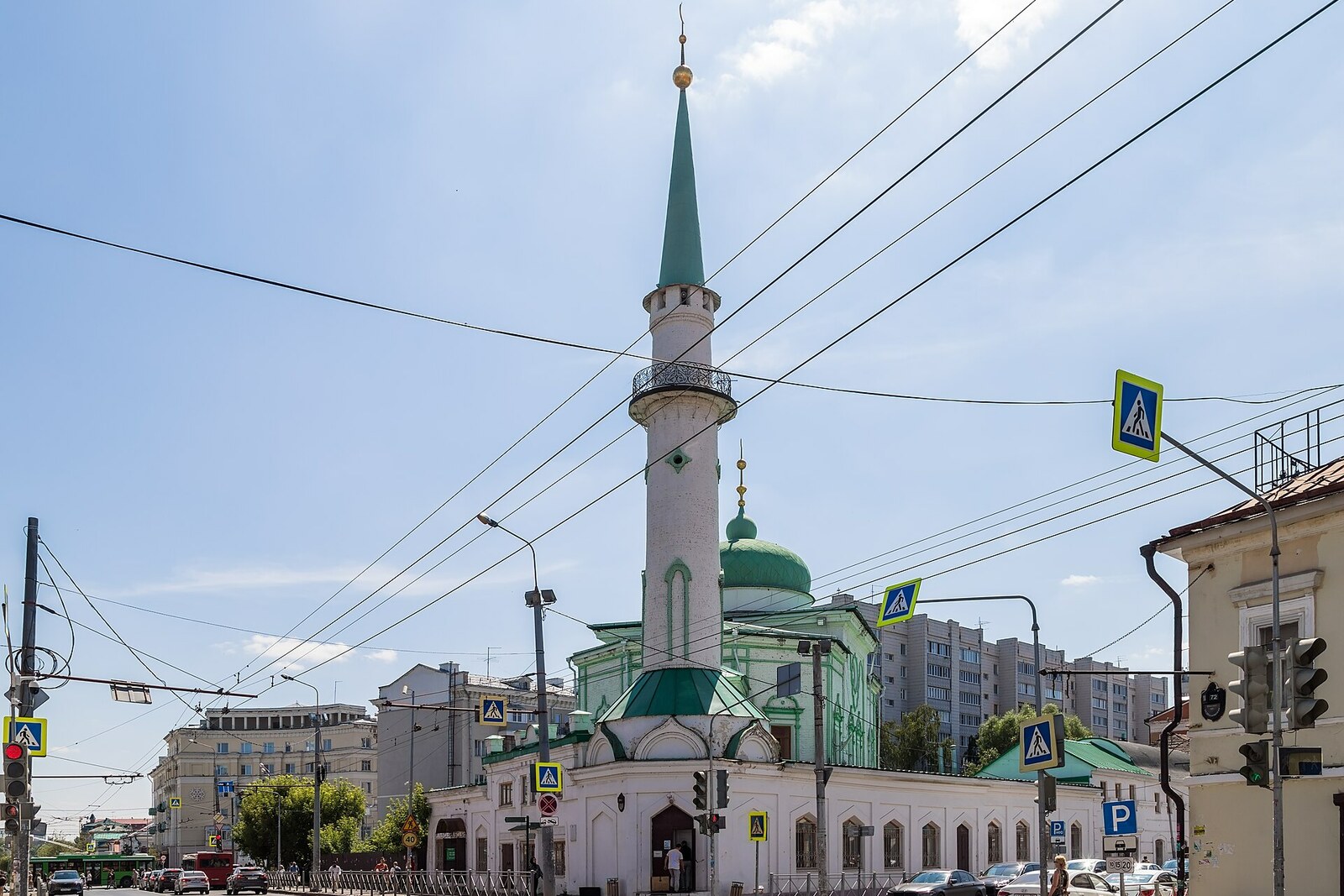 Nurulla Mosque and its tall minaret on the corner of a city block.