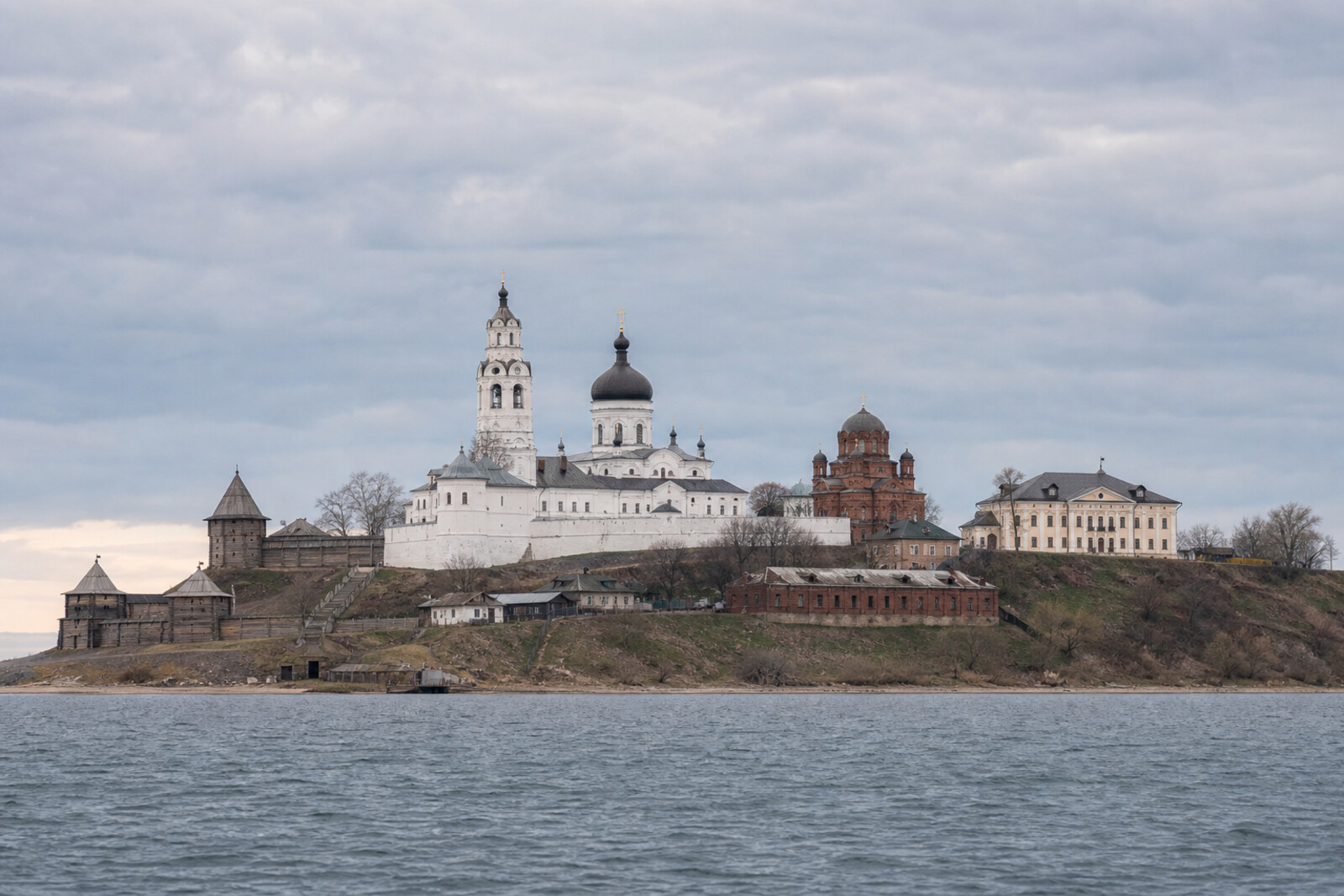 Sviyazhsk above the water, with monastery walls, wooden fortress motifs, and the route's austere buildings.