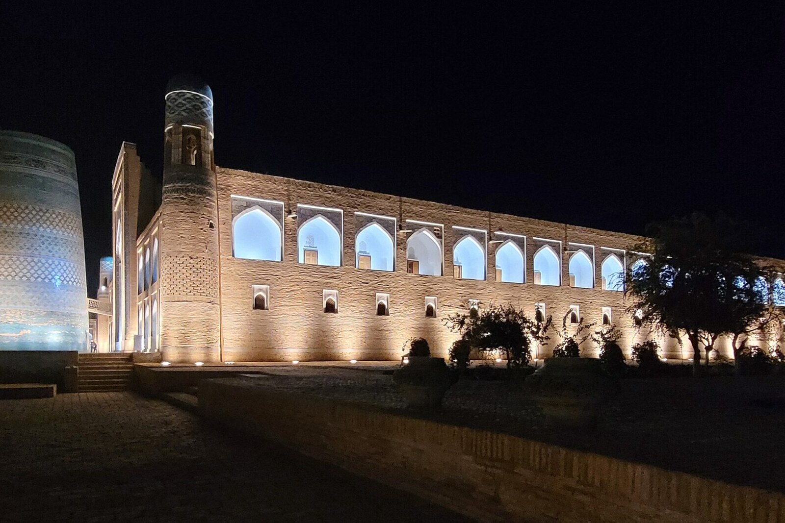 The turquoise cylinder of Kalta Minor beside the facade of Muhammad Amin Khan Madrasa.