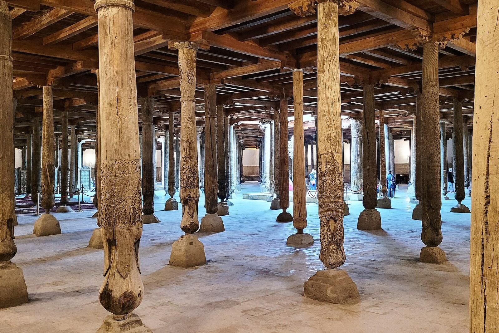 The dimly lit hall of Juma Mosque, with rows of carved wooden columns.