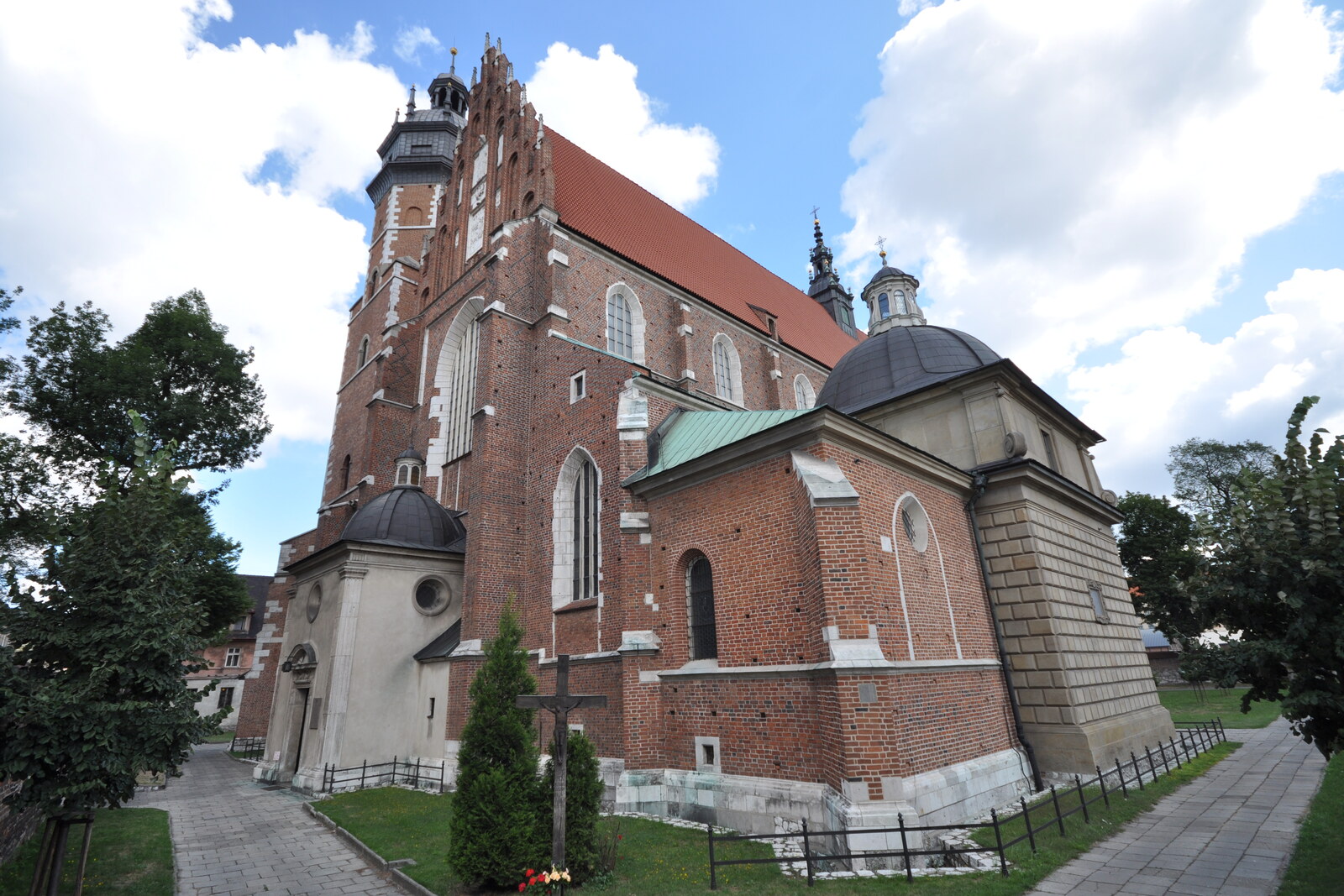 A tall Gothic church with a tower and a Baroque gable beneath a blue sky
