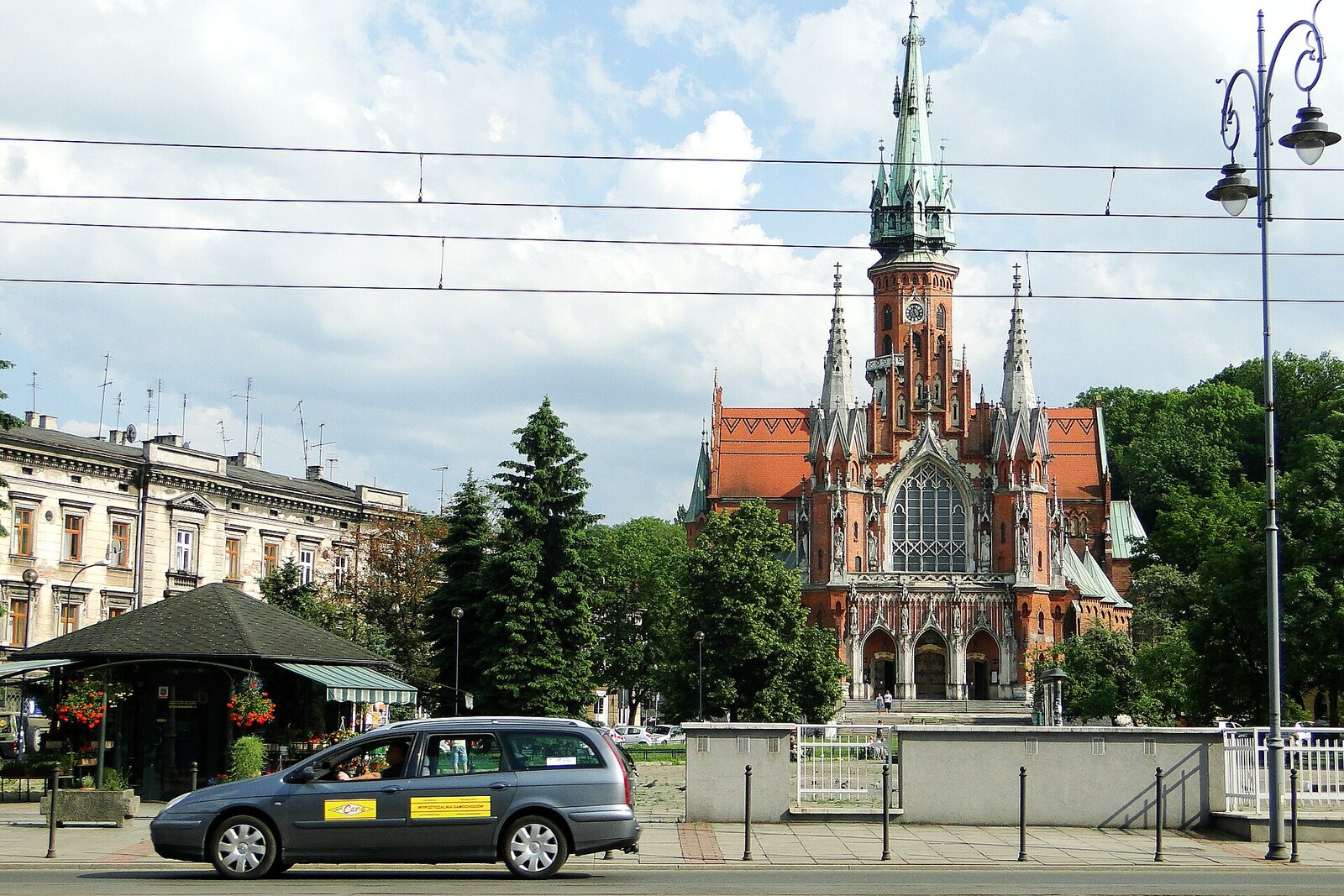 A triangular square with the spire of St. Joseph's Church in the background.
