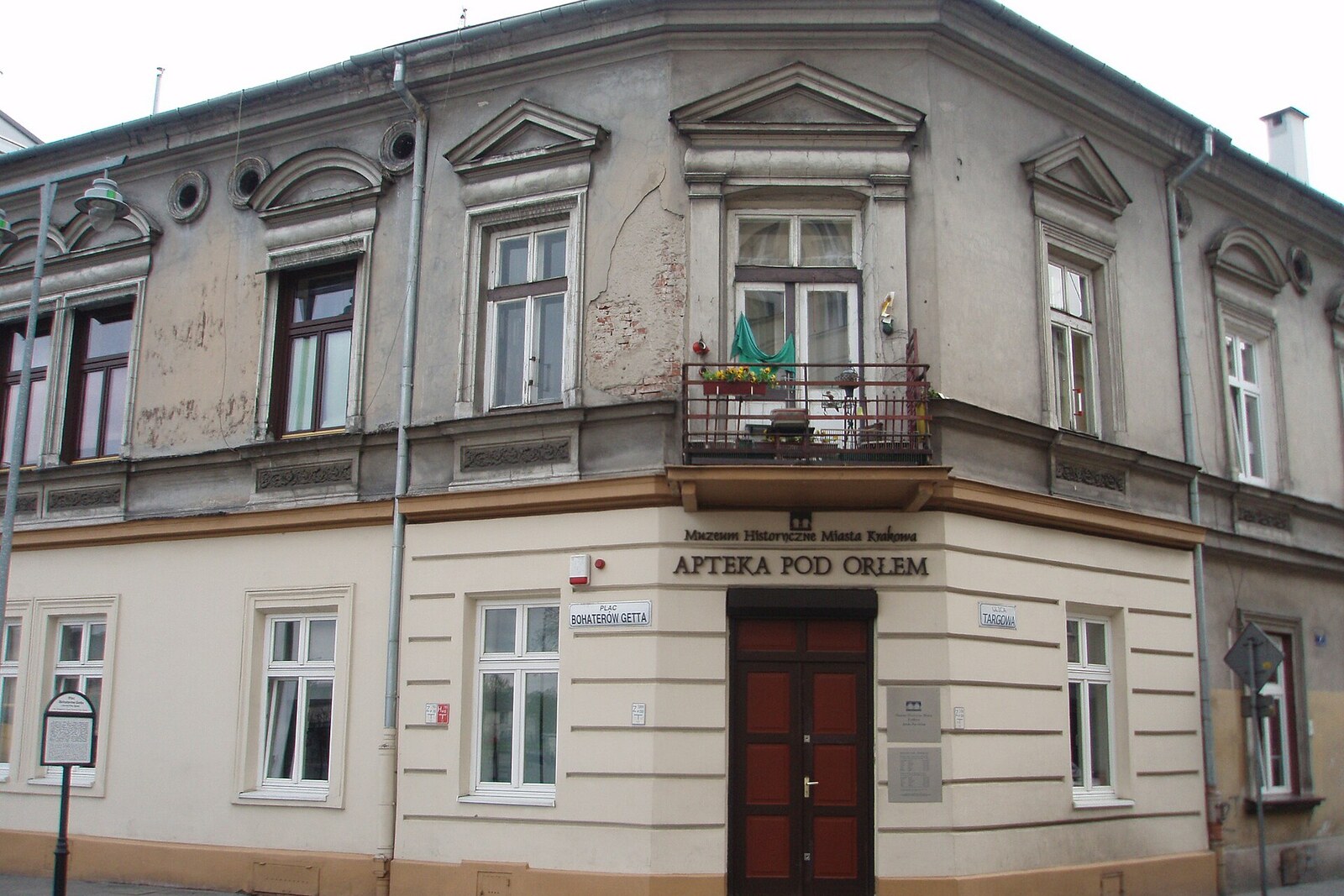 A low, light-colored building with the sign “Apteka pod Orłem.”