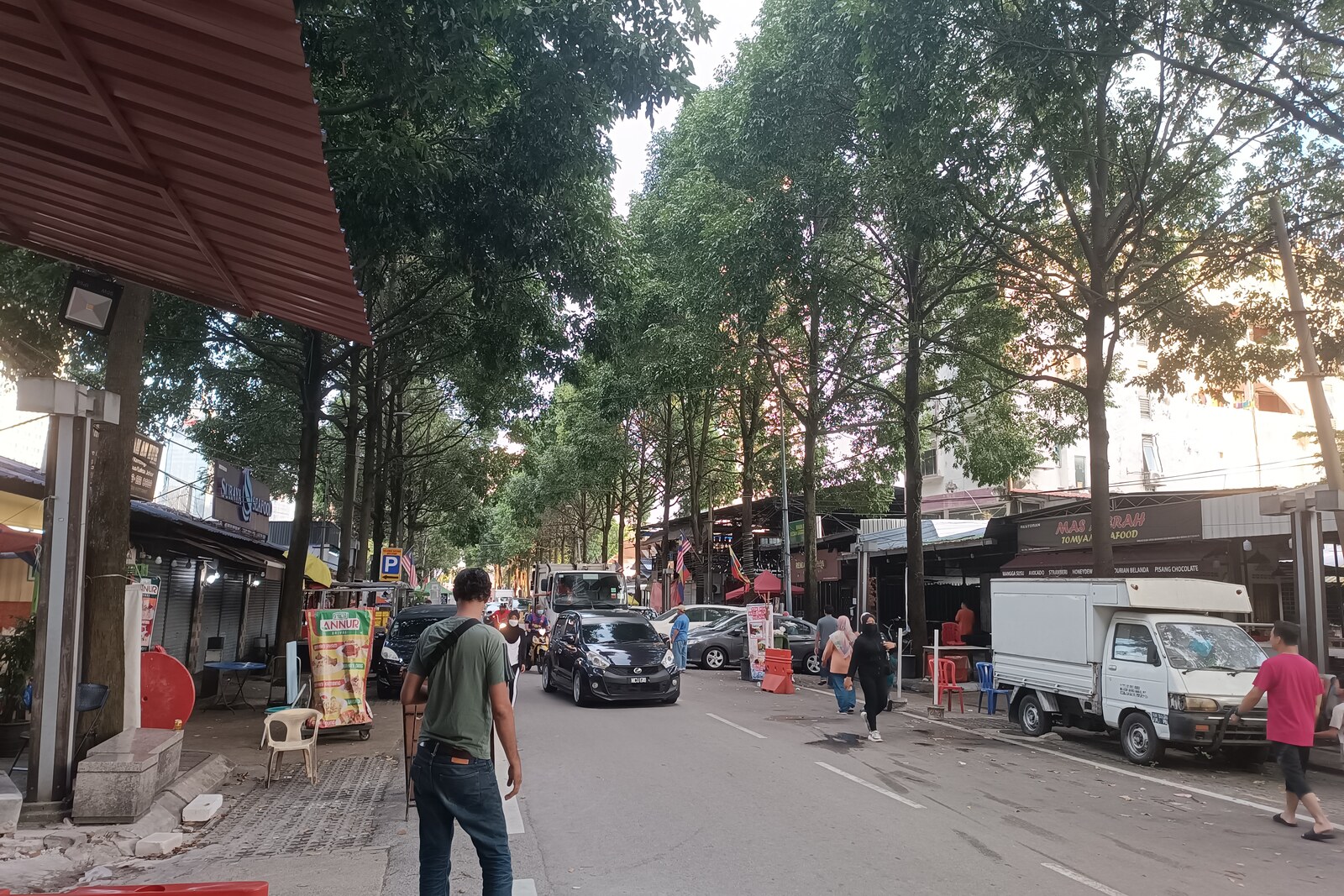 A street with wooden houses and stalls in Kampung Baru.