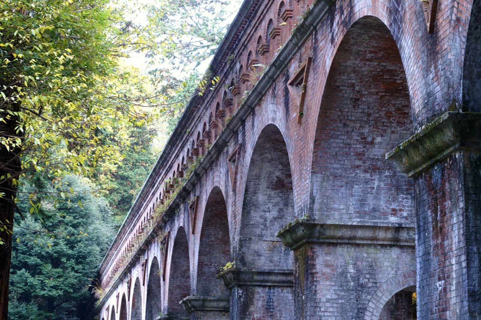 The brick Suirokaku aqueduct with arches amid greenery