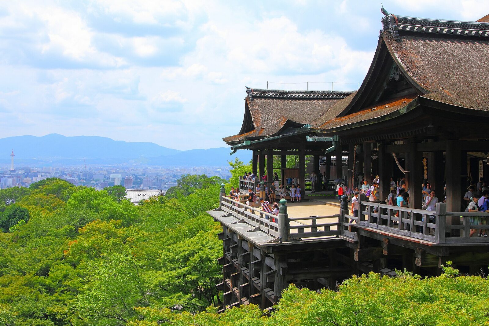 The main hall of Kiyomizu-dera Temple, with its wooden terrace above the greenery and a view of the city.
