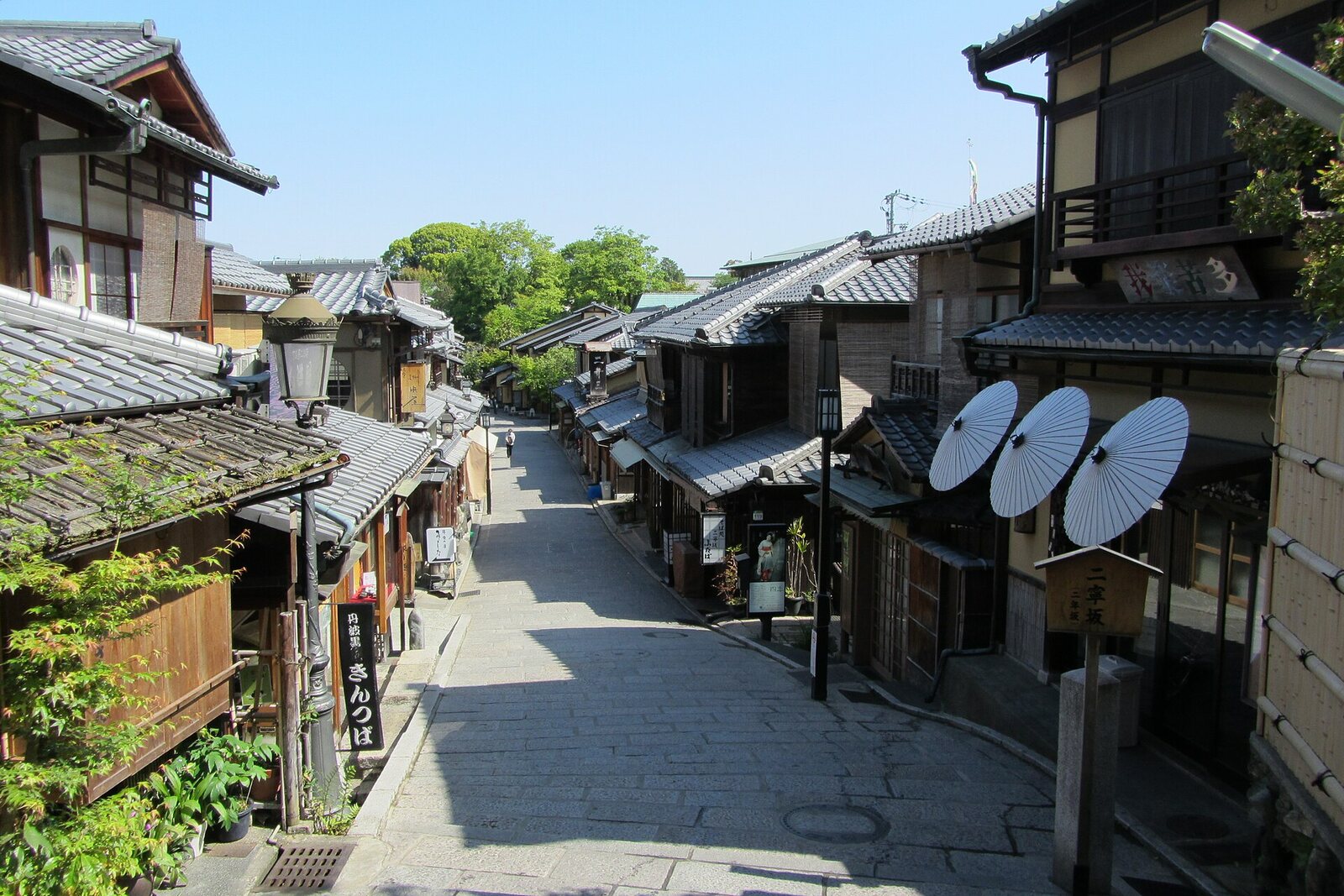 Ninenzaka with paper umbrellas, stone paving, and wooden houses.