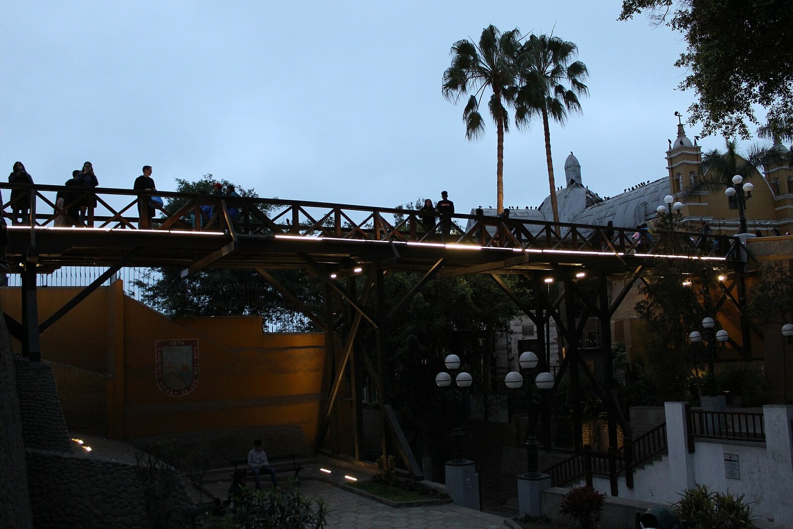 The wooden Puente de los Suspiros bridge spans a green ravine in the Barranco district