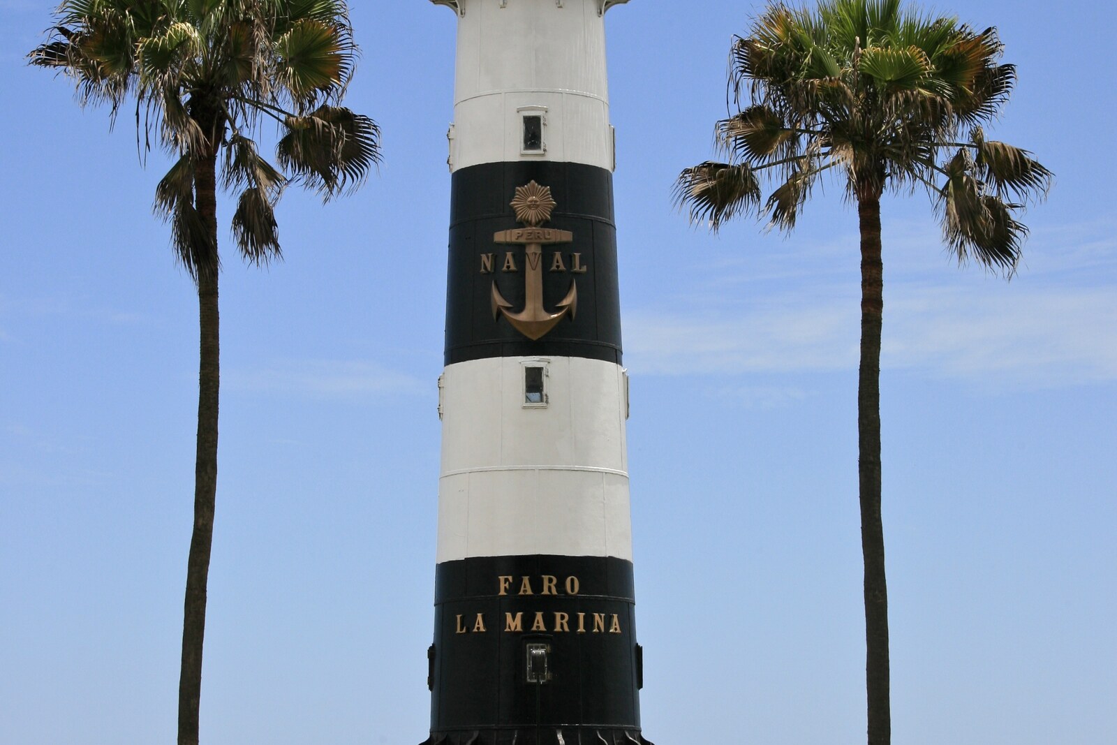 The black-and-white La Marina Lighthouse on a green lawn