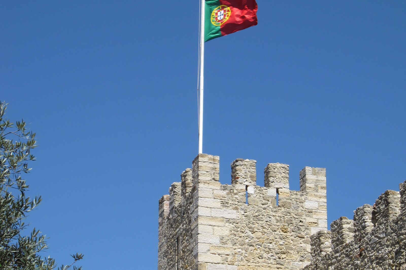 The fortress walls and towers of Castelo de São Jorge at the top of the hill