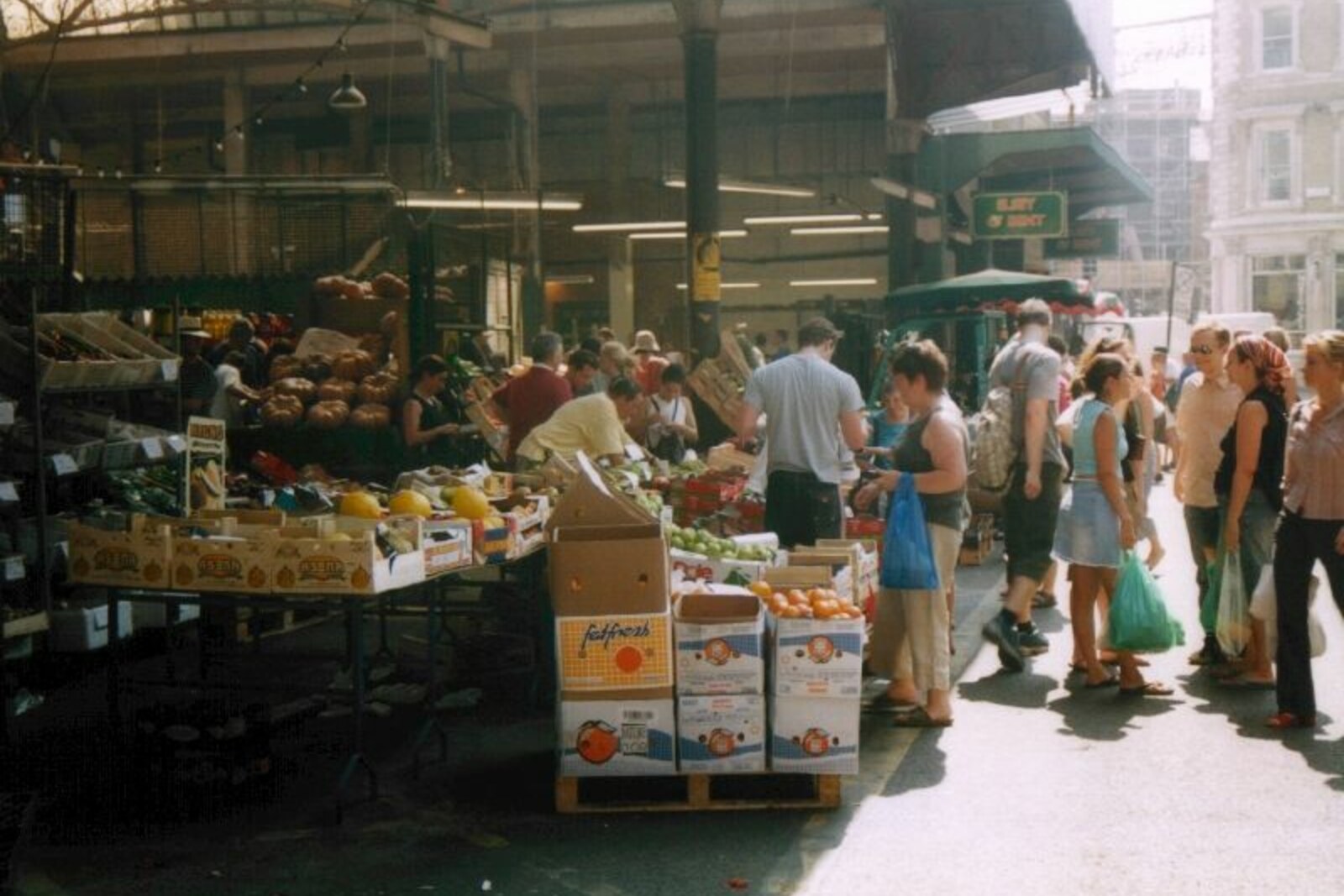 Food stalls and people at Borough Market beneath a green metal roof