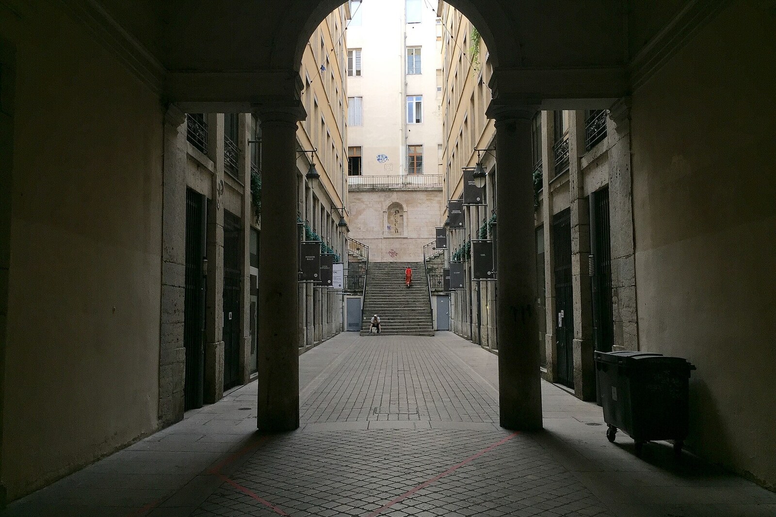 An empty Passage Thiaffait in Lyon, a long covered corridor with vaults and shop windows on both sides.