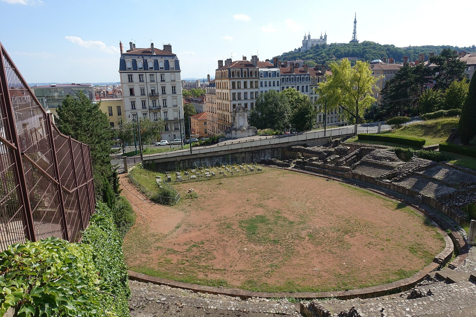 Ruins of the Amphitheatre of the Three Gauls in Lyon, with an oval arena and stone walls, without people.