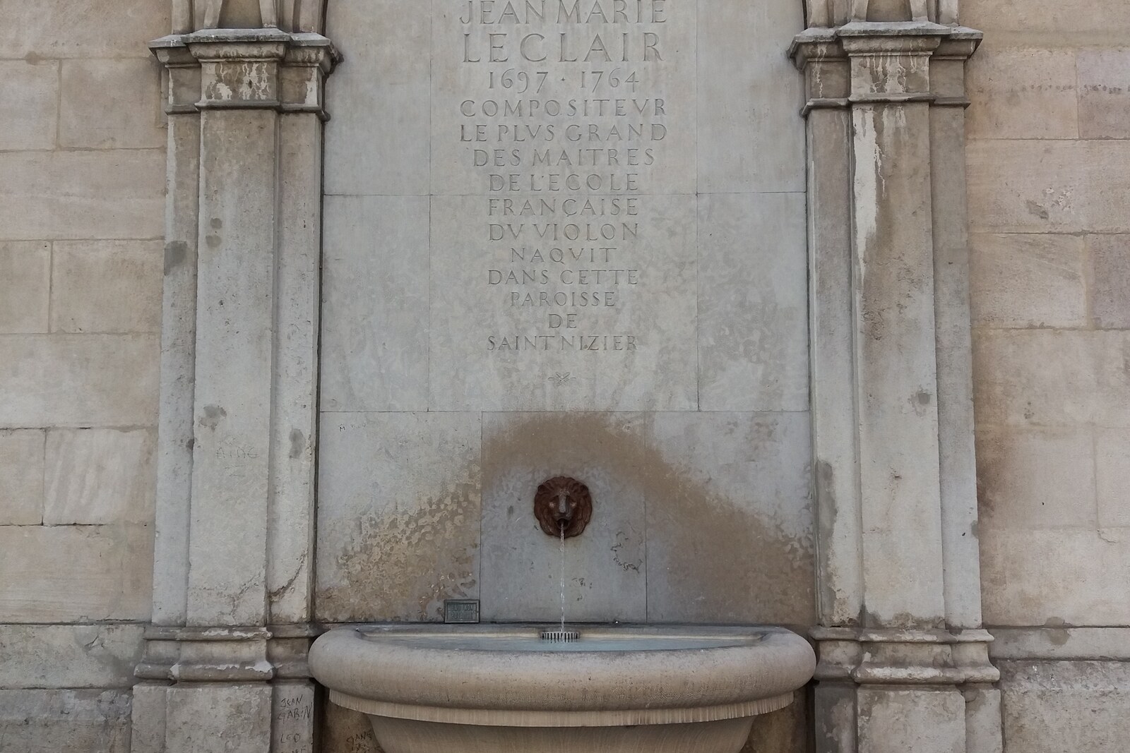 Stone fountain and the Gothic façade of the Church of Saint-Nizier in Lyon