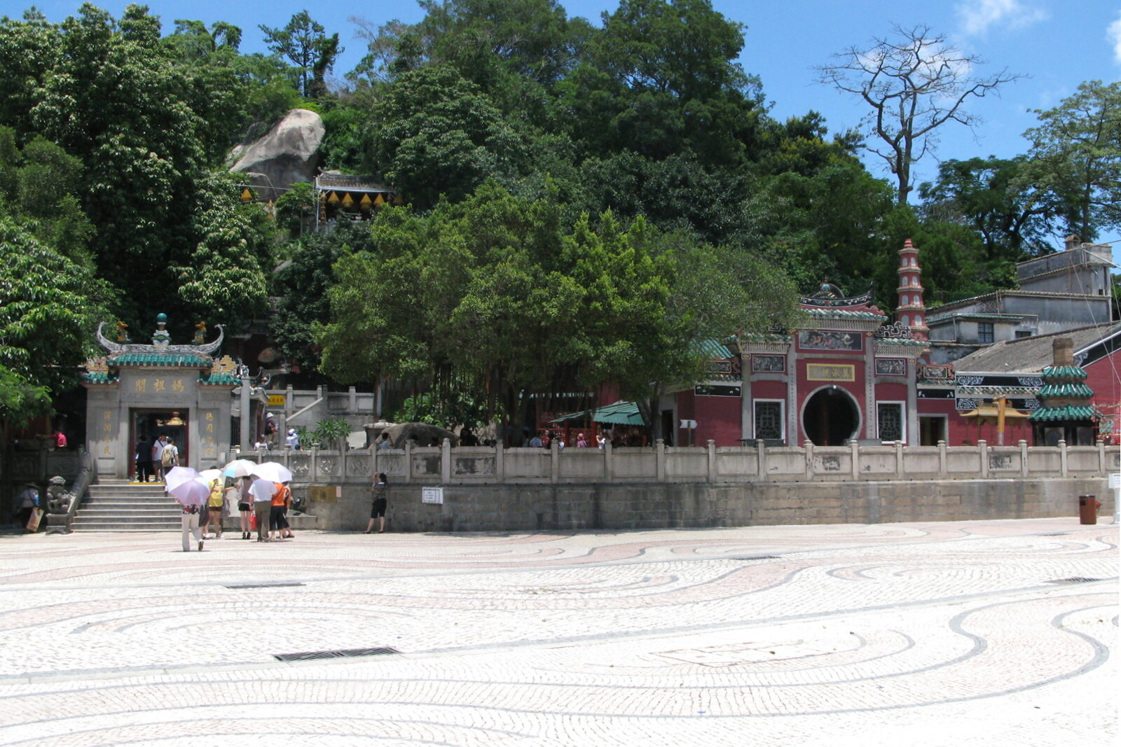 A-Ma Temple with the square in front of its entrance and a green slope behind it.