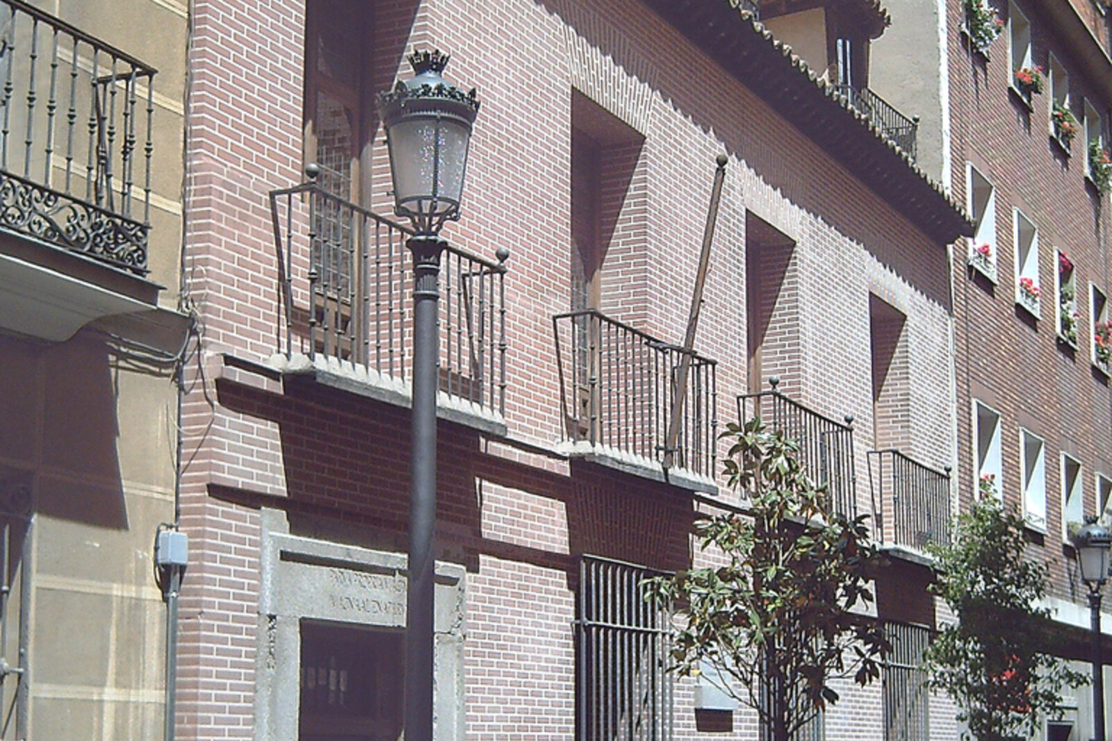 Exterior of the Lope de Vega House Museum with green shutters and courtyard garden, Madrid.