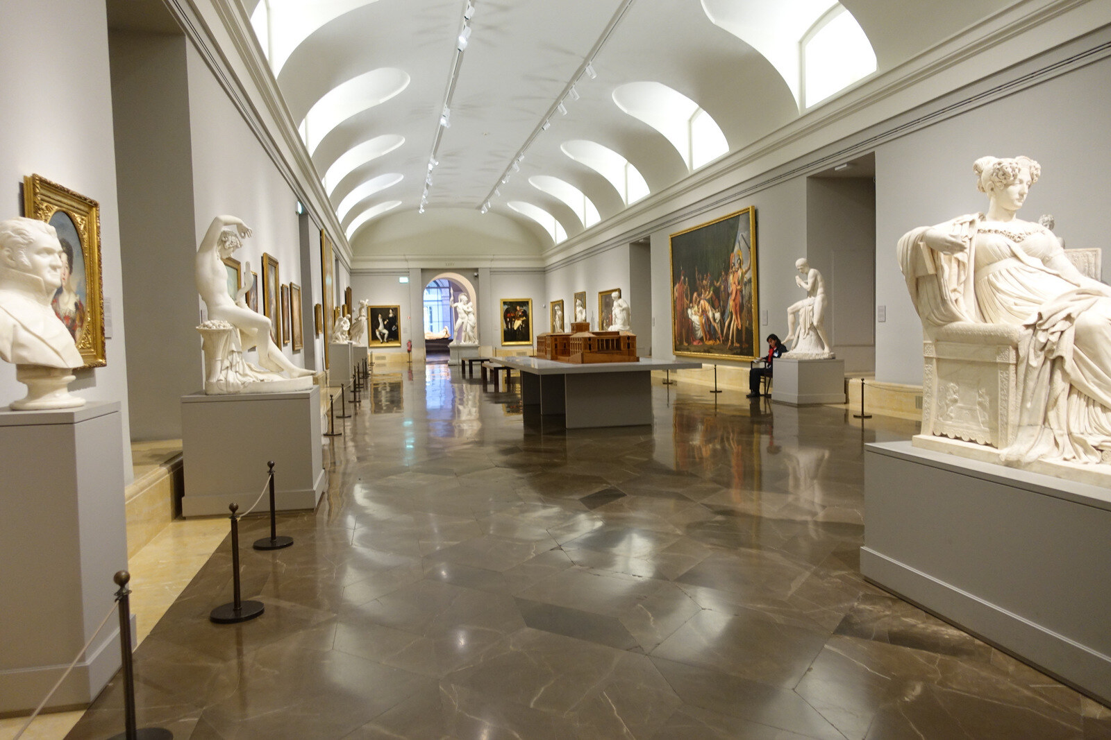 The facade of the Prado Museum with columns and a statue of Diego Velázquez in front of the entrance