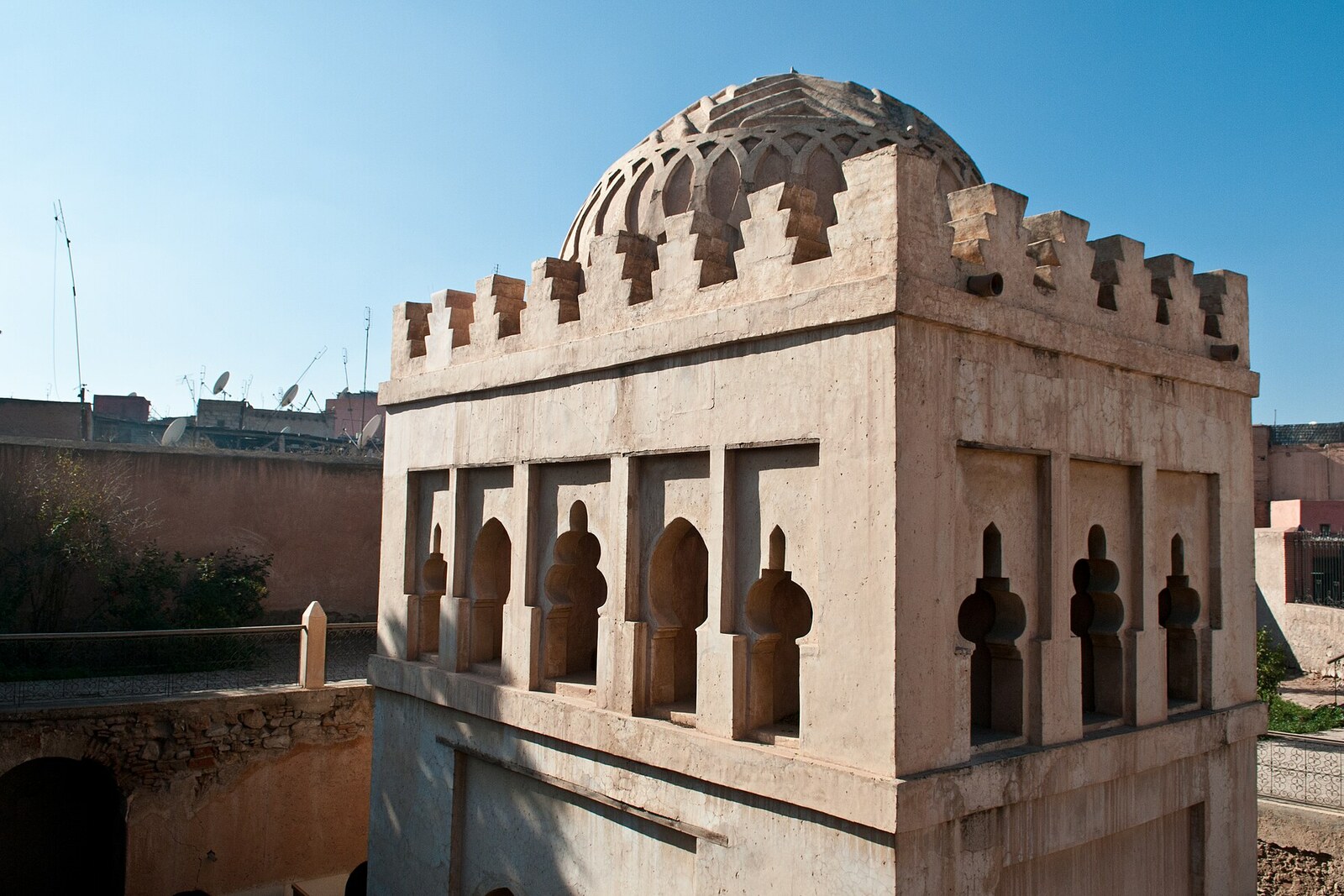 Almoravid domed pavilion with vaults and arches against a red wall