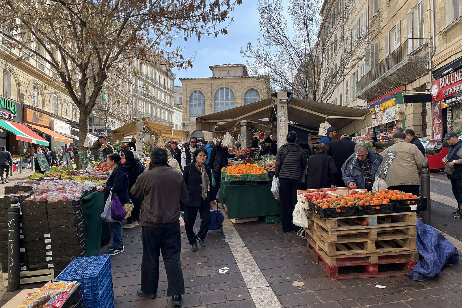 Place de marché avec des étals et des maisons à Noailles