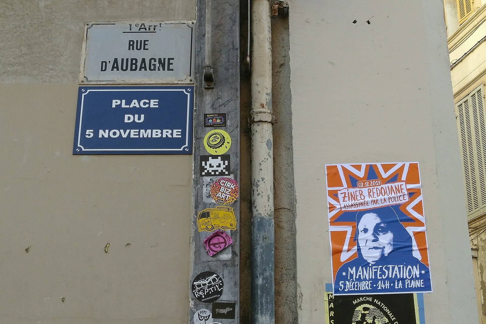 Plaque de marbre sur un mur portant l’inscription « Place du 5 novembre » à Marseille